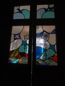 Recent window, free flowing designs with sandblasted blue on white flower on left and painted rose from my college days (40 years ago) on the right. Some sandblasted clear too.